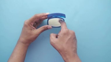 Mavi arka planda petrol jölesi kullanan bir adamın üst görüntüsü 