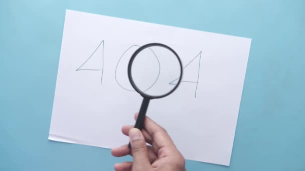 Tangan dalam kaca pembesar memeriksa kesalahan 404. — Stok Video