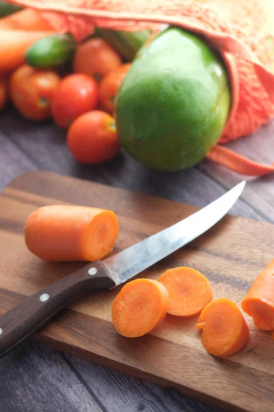 Zanahorias frescas en la tabla de cortar en la mesa — Foto de Stock