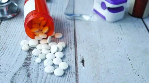 Píldoras médicas de color blanco derramándose en la mesa — Vídeo de stock