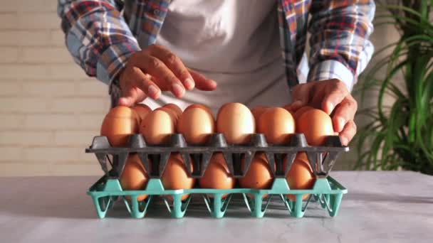 Χέρι πάρει τα αυγά από μια πλαστική θήκη στο τραπέζι — Αρχείο Βίντεο