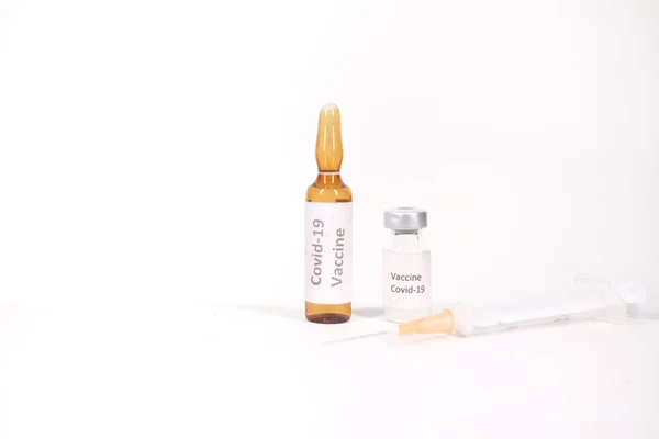 Close up da vacina contra o coronavírus e seringa sobre fundo branco — Fotografia de Stock