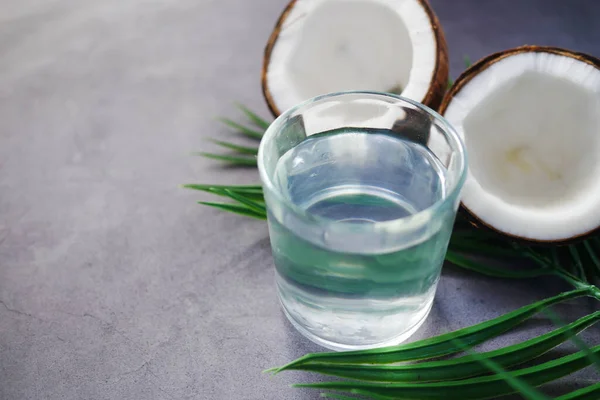 Fatia de coco fresco e vidro de água de coco na mesa — Fotografia de Stock