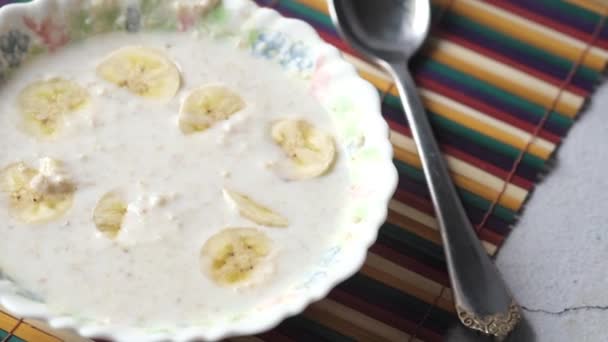 Desayuno saludable con copos de avena y plátano en la mesa, de arriba hacia abajo — Vídeo de stock