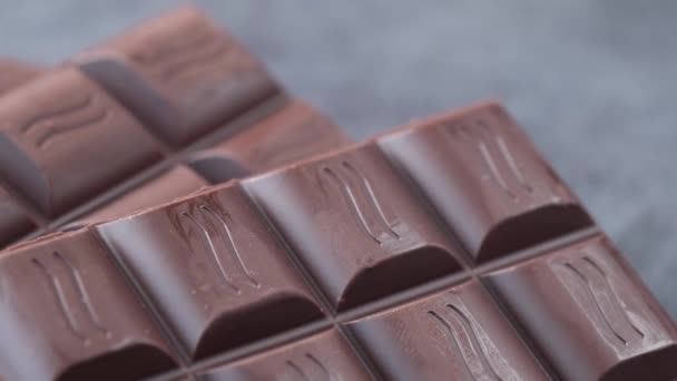 Chocolate negro en un plato sobre fondo rosa — Vídeo de stock