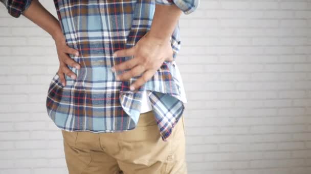 Молодий чоловік страждає біль у спині крупним планом — стокове відео