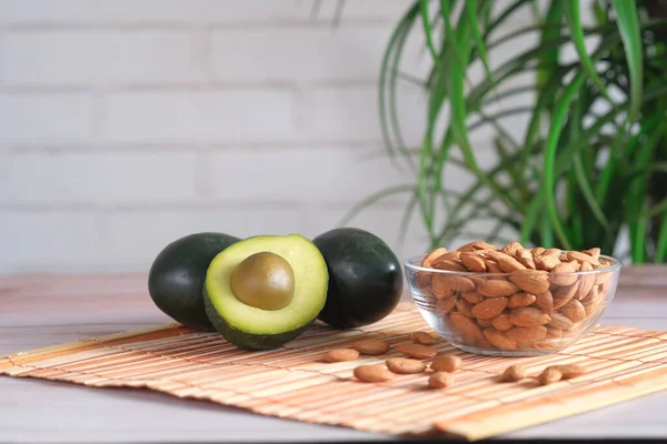 Närbild av skiva av avokado och blandad nöt på hackbrädan. — Stockfoto