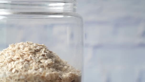 Oats flakes in a jar with spoon on table — Stock Video