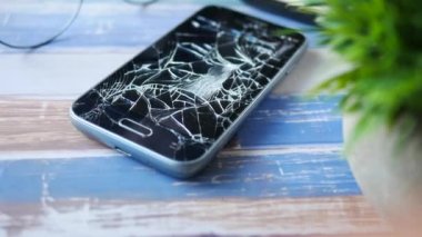  Ahşap arka planda kırılmış akıllı telefon 