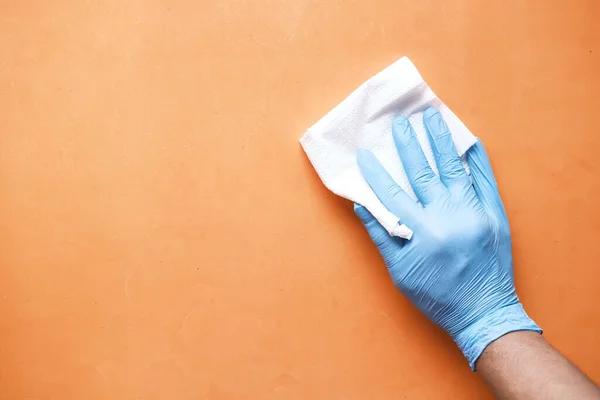 Hand in blue rubber gloves cleaning table with cloth — Stock Photo, Image