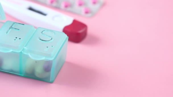 Caixa de pílula, termômetro, recipiente e embalagem blister em rosa — Vídeo de Stock