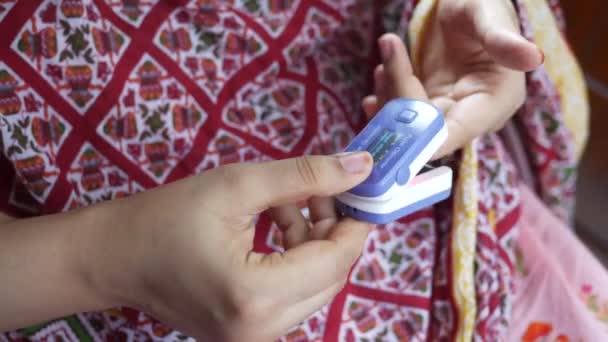 Tangan wanita muda menggunakan pulse oximeter — Stok Video