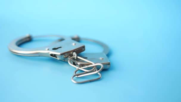 Close up of handcuff on blue background. — Stock Video