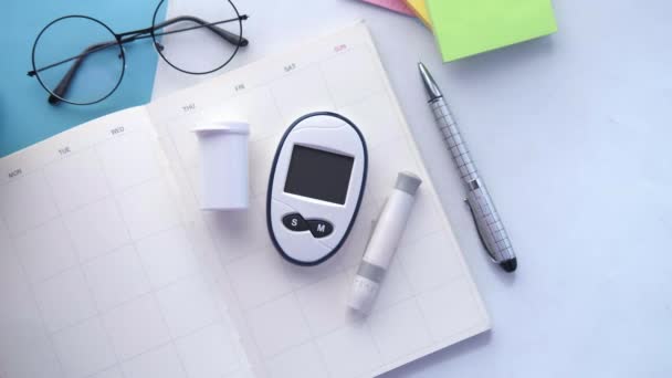 Herramientas de medición de la diabetes y un planificador en la mesa — Vídeos de Stock