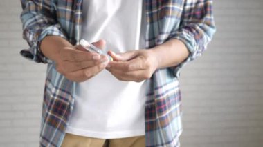 Genç adam elinde insülin kalemleri tutuyor. 