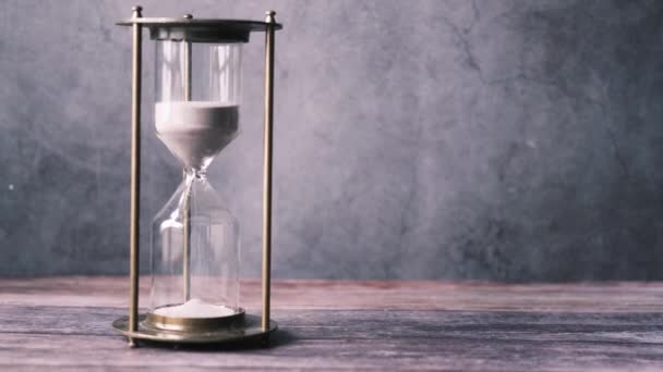 Timeglas på bordet, sand flyder gennem pæren af sandglas – Stock-video