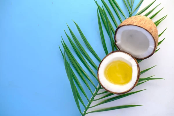 Rebanada de coco fresco, aceite y hoja en el fondo de color con espacio de copia — Foto de Stock