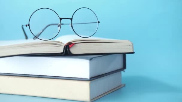 Open book, mug, eyeglass and a pencil on wooden table — Stock Video