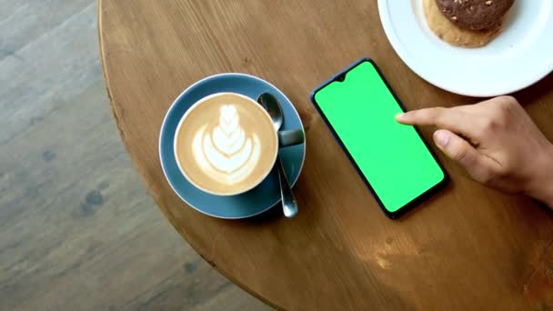 使用绿色屏幕的智能手机手放在茶几上 — 图库视频影像