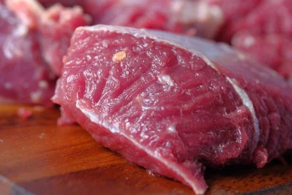 El primer plano de la carne cruda en la tabla de cortar en una tabla de cortar —  Fotos de Stock