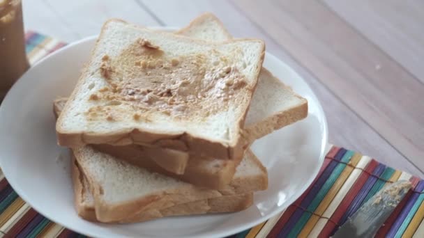 Vista superior de manteiga de amendoim e pilha de pão na mesa — Vídeo de Stock