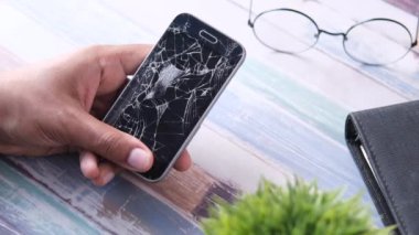 Kırık akıllı telefonu tutan adama yakın dur..