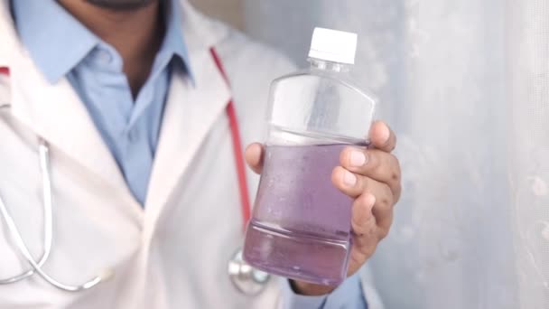 Médico mão segurar bochecho recipiente líquido — Vídeo de Stock