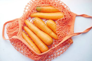 Beyaz poşette taze havuç. 