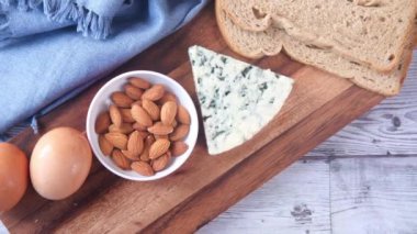 Peynir, süt, kahverengi ekmek ve badem fıstığı masada..