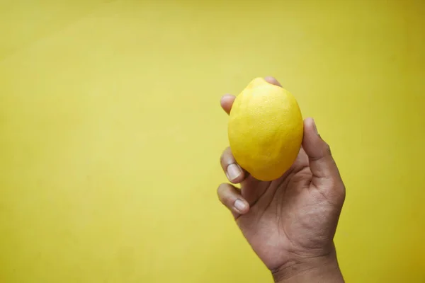 Handtag gul citron på gul bakgrund — Stockfoto