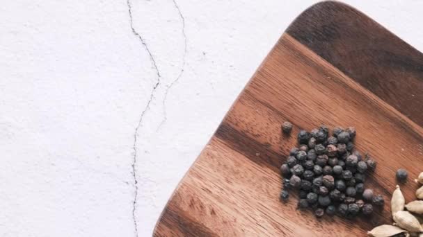 Spices and herbs on chopping board on table, top view — Stock Video