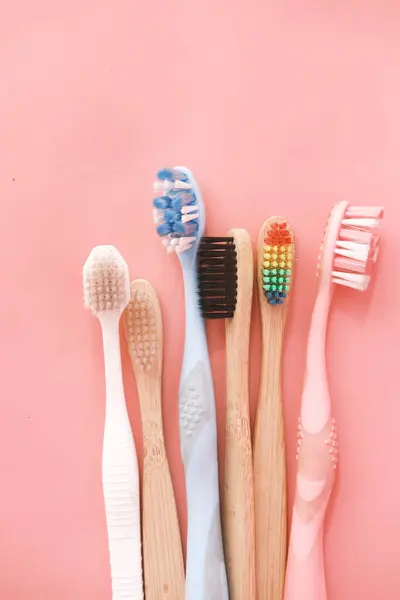 Cepillos de dientes coloridos sobre fondo rosa — Foto de Stock