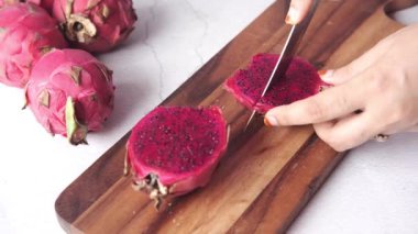 Genç kadınlar doğrama tahtasıyla ejderha meyvesi kesiyorlar..