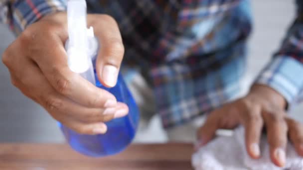 Mão em luvas de borracha azul segurando a mesa de limpeza do frasco de spray — Vídeo de Stock