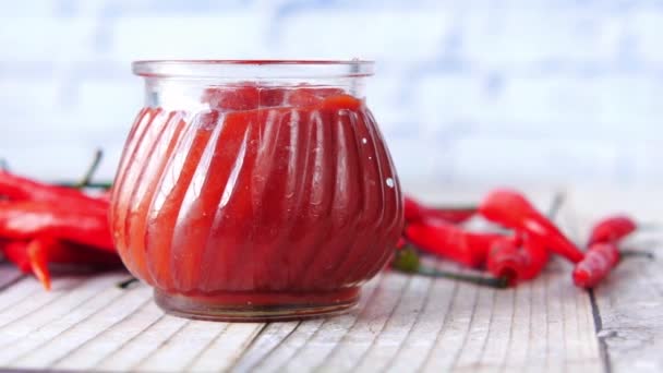 Salsa de tomate y chile en un frasco pequeño con tomate fresco en la mesa — Vídeos de Stock