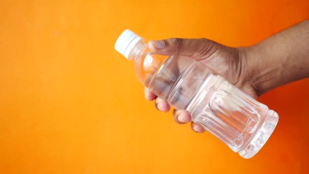 Hand houden vers drinkwater in een plastic fles — Stockvideo