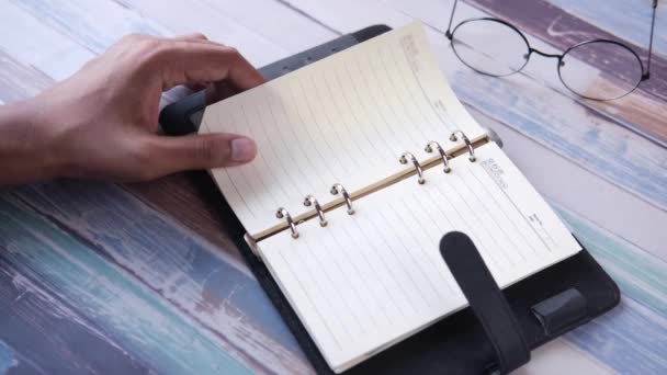 Zbliżenie męskiej dłoni obracającej pager pamiętnika — Wideo stockowe