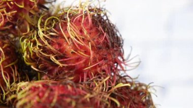 Masadaki kesme tahtasındaki Rambutan yığını 