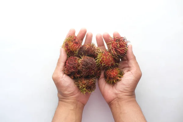 Main tenir rambutan fruits sur fond blanc — Photo