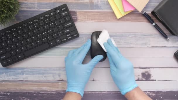 Mano en guantes de goma azul y tejido blanco desinfectando el ratón del ordenador — Vídeo de stock