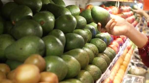 Jonge vrouwen hand houden avocado winkelen in de winkel — Stockvideo