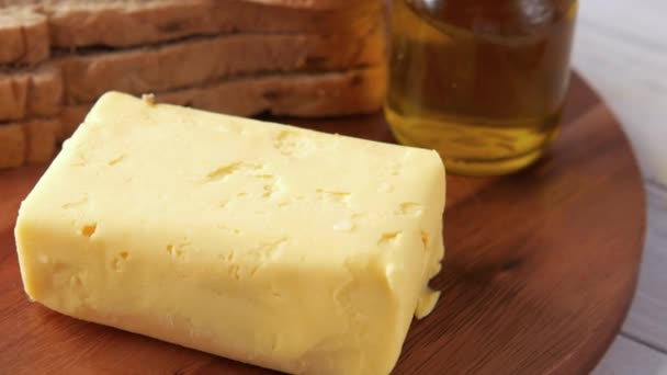 Rebanada de mantequilla y pan integral en la tabla de picar — Vídeos de Stock