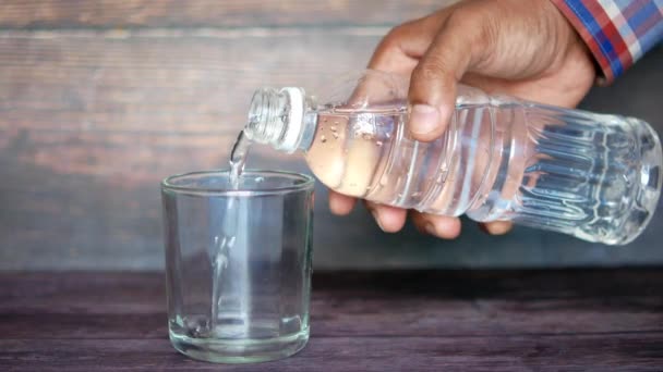 Versando acqua in un bicchiere sul tavolo — Video Stock