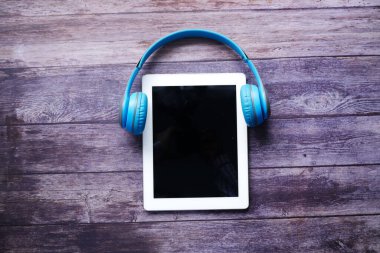 Ses kitabı konsepti. Masada kulaklık ve dijital tablet 