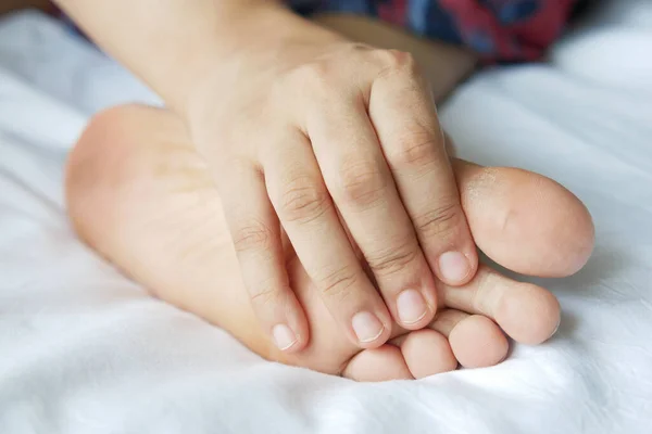 Primer plano en los pies de las mujeres y masaje de manos en el lugar de lesión. —  Fotos de Stock