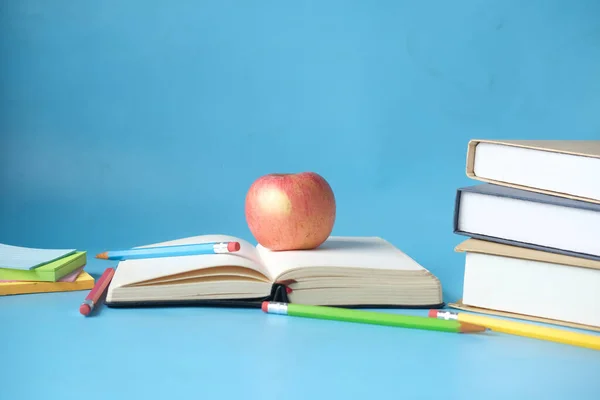 Concept noir à l'école avec pomme sur un livre sur bleu — Photo