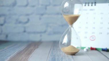 Takvimdeki kum saati ve kum saati ampulünden akıyor.