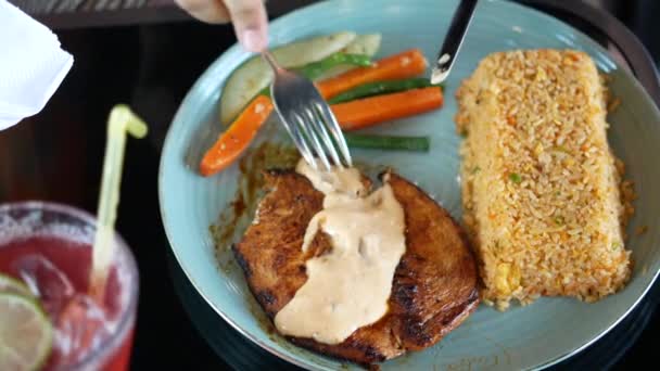 Grillcsirke darabolása késsel és villával rizzsel és salátával tányéron — Stock videók