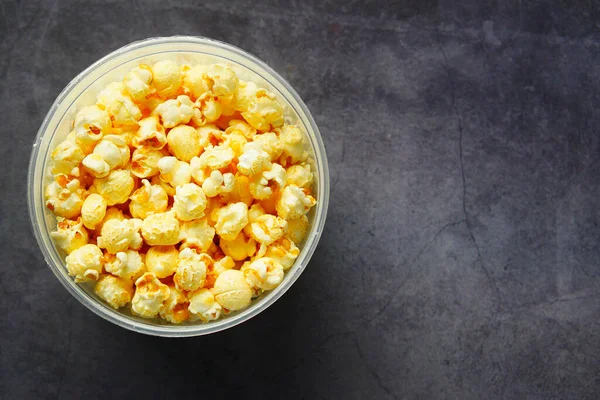 Popcorn v misce na černém pozadí dlaždice — Stock fotografie