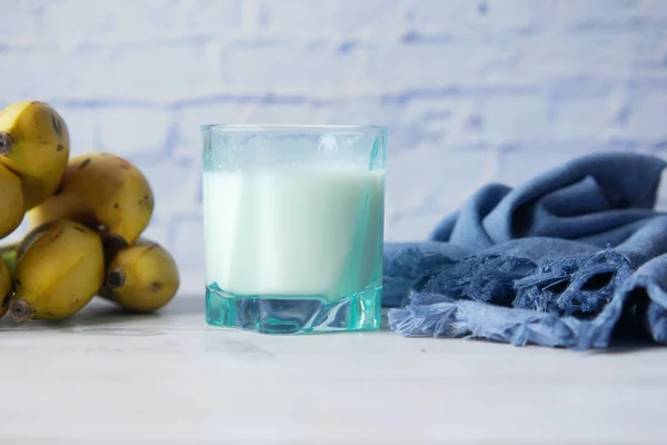 Bicchiere di latte e banana sul tavolo al mattino — Foto Stock